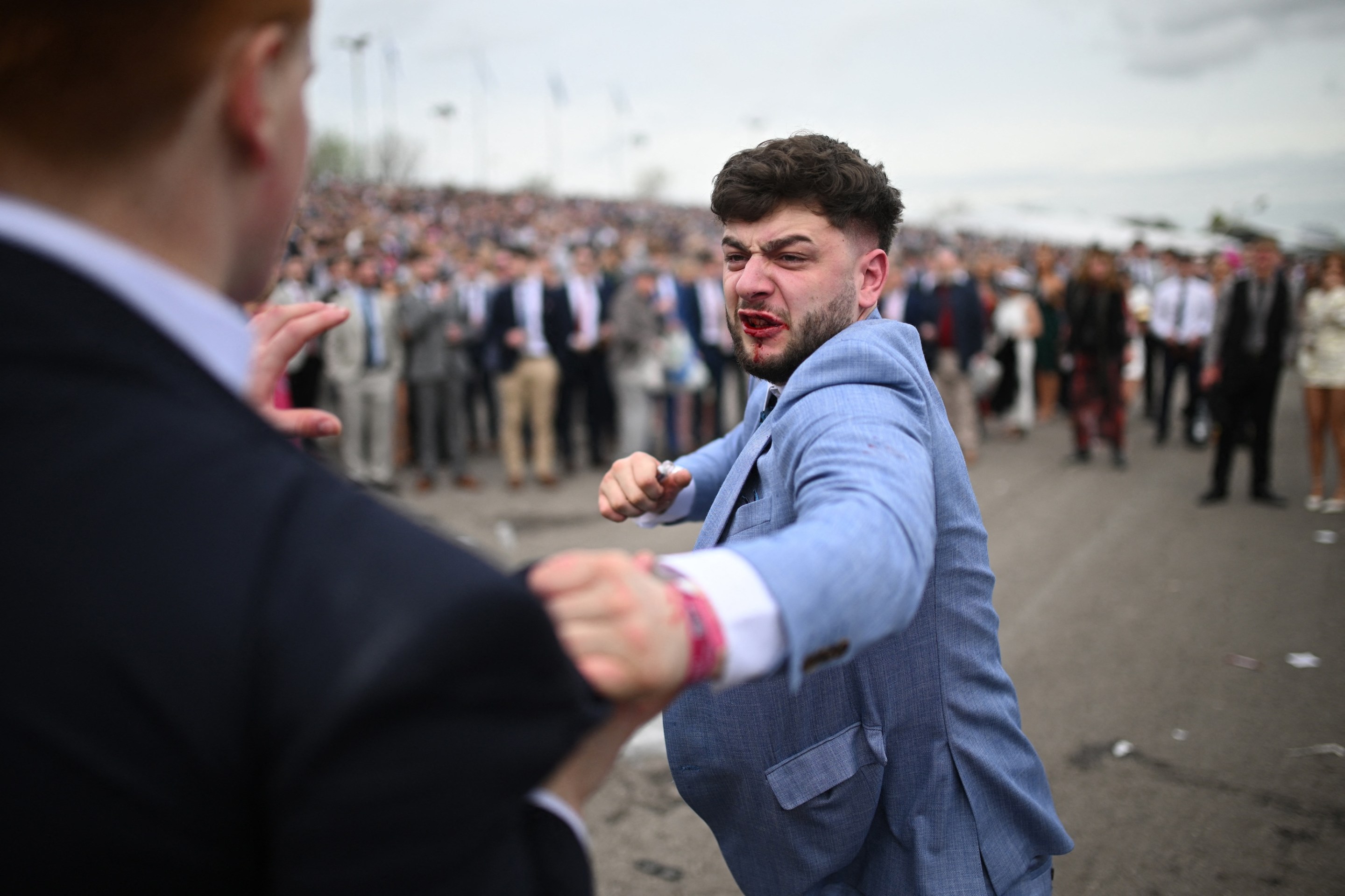 Racegoers fight each other as they scuffle on the second day of the Grand National Festival horse race meeting at Aintree Racecourse in Liverpool, north-west England, on April 12, 2024. (Photo by Oli SCARFF / AFP)