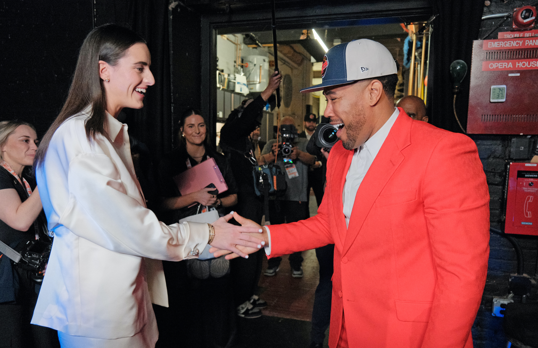 Caitlin Clark daps up Jake From State Farm, for some reason, at the WNBA Draft