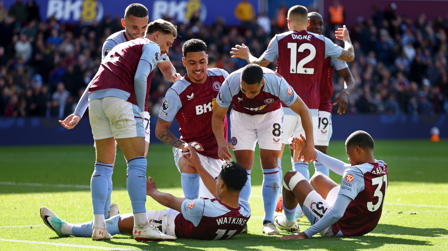 Youri Tielemans of Aston Villa helps up Ollie Watkins and Leon Bailey, the scorer of their third goal, after celebrating their third goal during the Premier League match between Aston Villa and AFC Bournemouth at Villa Park on April 21, 2024 in Birmingham, England.