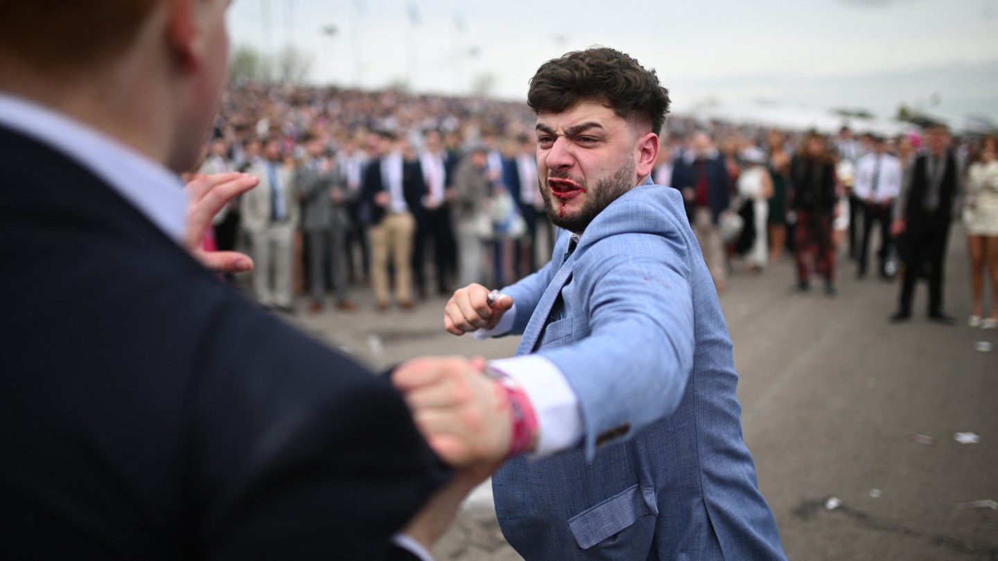 Racegoers fight each other as they scuffle on the second day of the Grand National Festival horse race meeting at Aintree Racecourse in Liverpool, north-west England, on April 12, 2024.
