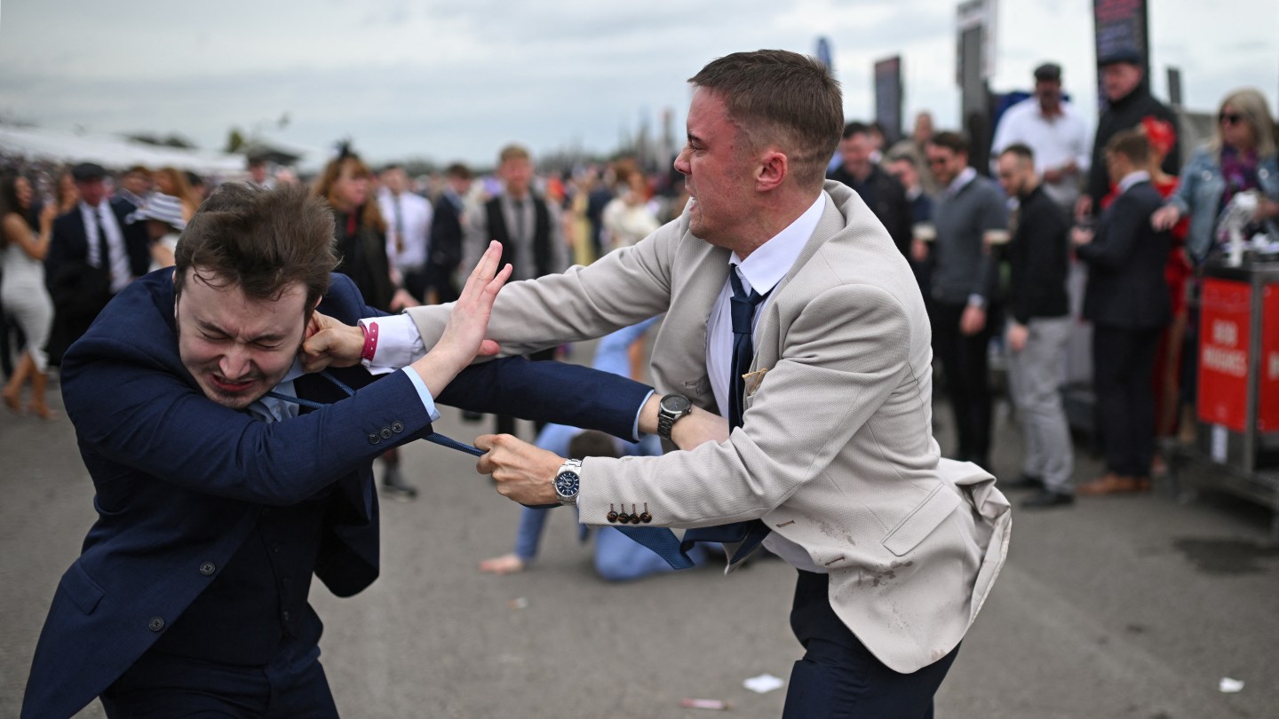 Racegoers fight each other as they scuffle on the second day of the Grand National Festival horse race meeting at Aintree Racecourse in Liverpool, north-west England, on April 12, 2024.