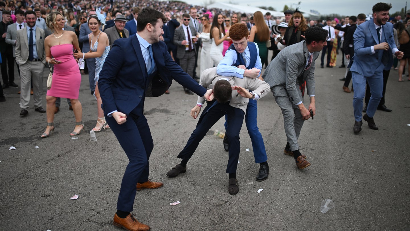 Racegoers fight each other as they scuffle on the second day of the Grand National Festival horse race meeting at Aintree Racecourse in Liverpool, north-west England, on April 12, 2024.