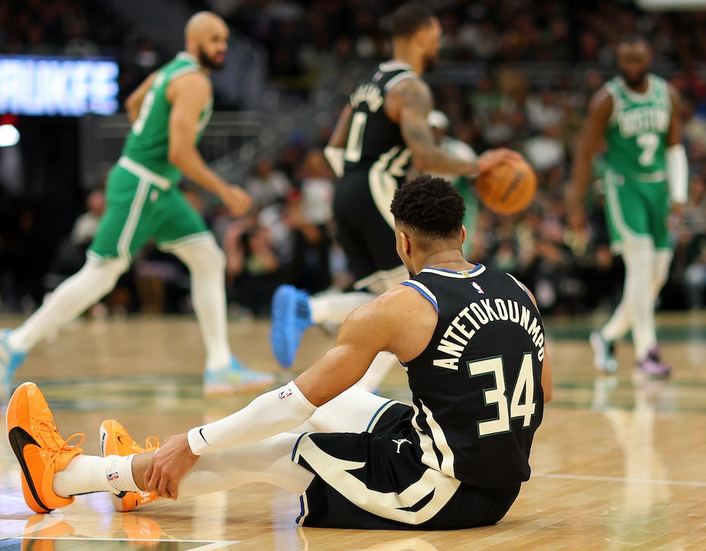 Giannis Antetokounmpo #34 of the Milwaukee Bucks sits injured on the court during the second half of a game against the Boston Celtics on April 09, 2024 in Milwaukee, Wisconsin.