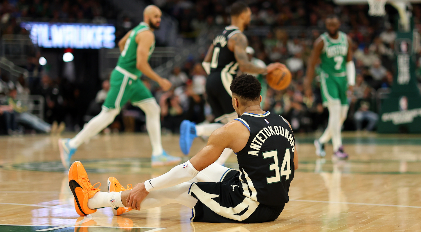 Giannis Antetokounmpo #34 of the Milwaukee Bucks sits injured on the court during the second half of a game against the Boston Celtics on April 09, 2024 in Milwaukee, Wisconsin.