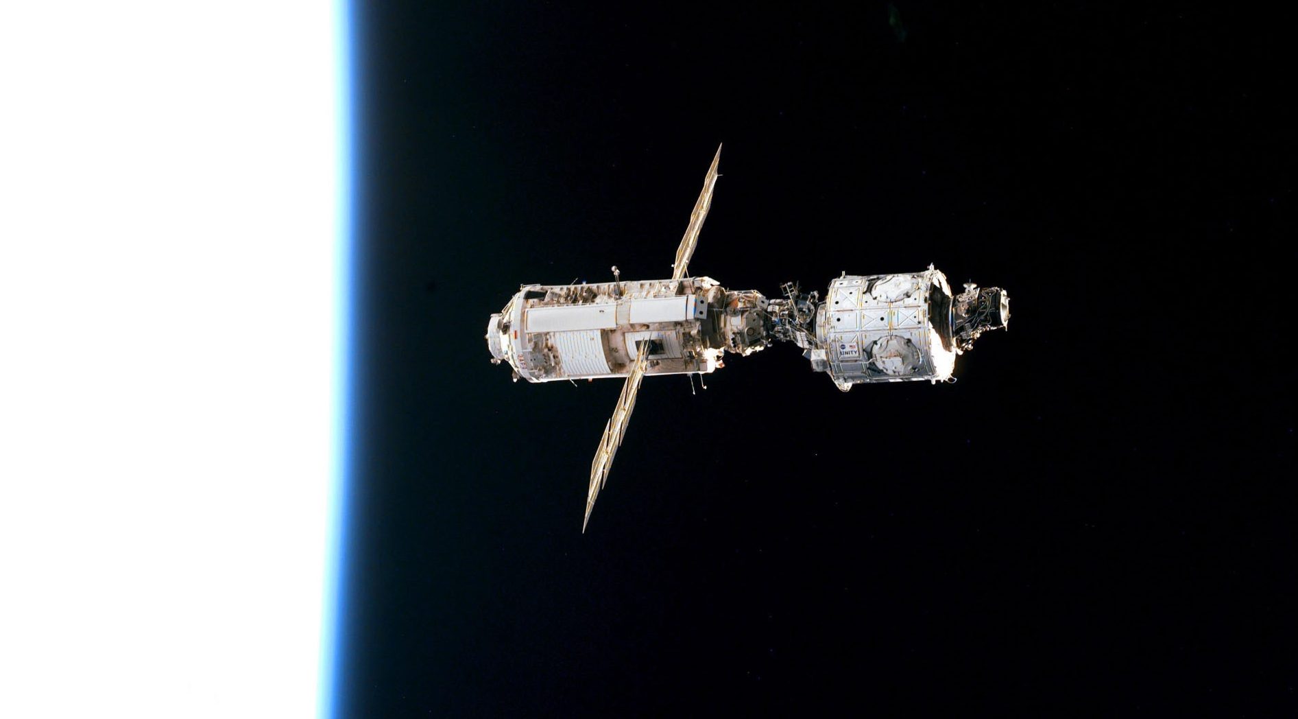 The mated Russian-built Zarya (left) and U.S.-built Unity modules are backdropped against the blackness of space over Earth's horizon shortly after leaving Endeavour's cargo bay December 13, 1998. After being released from the shuttle Endeavour, the international space station was orbiting the Earth on its own today -- ``a bright new star'''' not to be visited again until May. (photo by NASA)