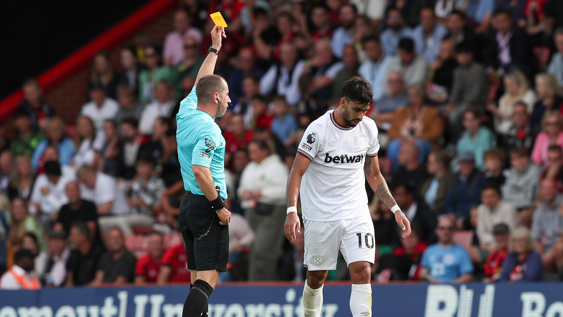 Referee Peter Bankes shows a yellow card to Lucas Paqueta of West Ham United during the Premier League match between AFC Bournemouth and West Ham United at Vitality Stadium on August 12, 2023 in Bournemouth, England.