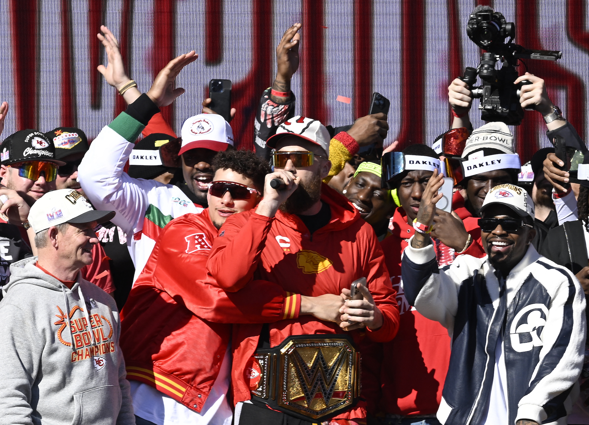 Kansas City Chiefs quarterback Patrick Mahomes (C L) hugs teammate tight end Travis Kelce (C) as they celebrate with teammates during the Chiefs' Super Bowl LVIII victory parade on February 14, 2024, in Kansas City, Missouri.