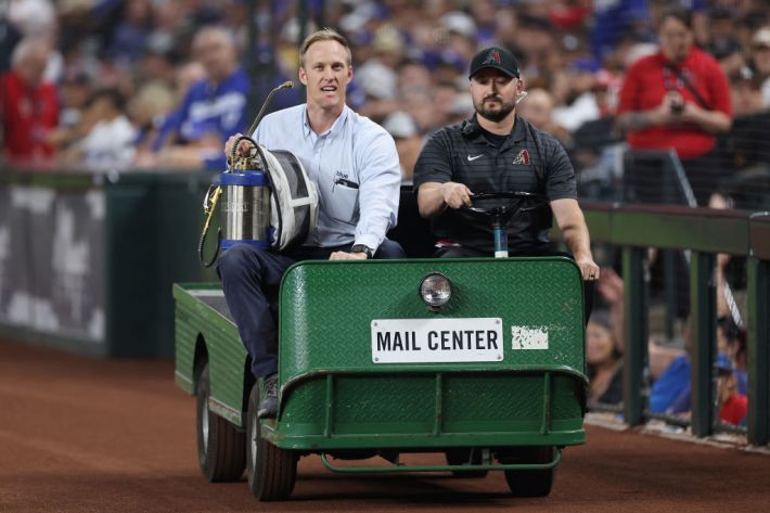 Beekeeper Matt Hilton (L) arrives to Chase Field to remove a colony of bees that formed on the net behind home plate during a delay to the MLB game between the Los Angeles Dodgers and the Arizona Diamondbacks on April 30, 2024 in Phoenix, Arizona