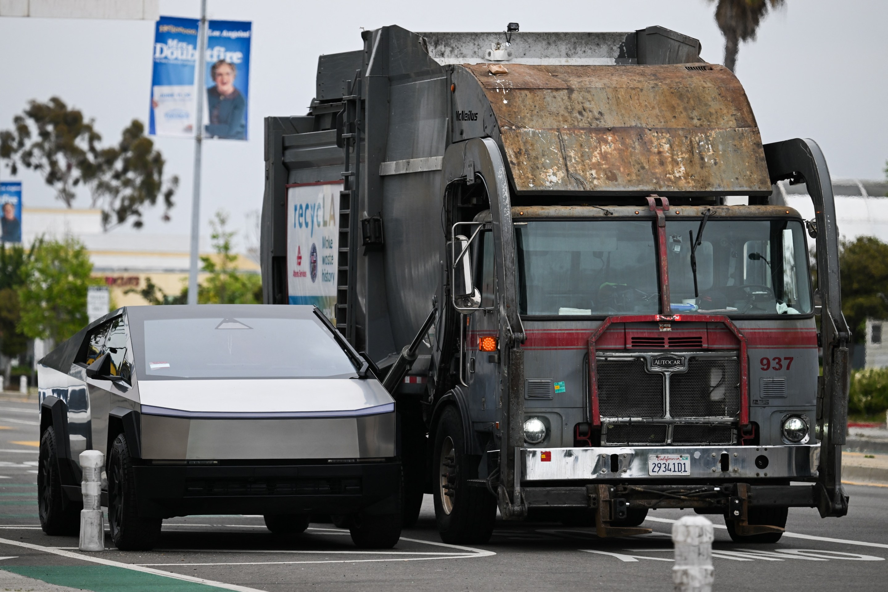 A Tesla Cybertruck electric vehicle sits parked next to a garbage truck in Los Angeles.