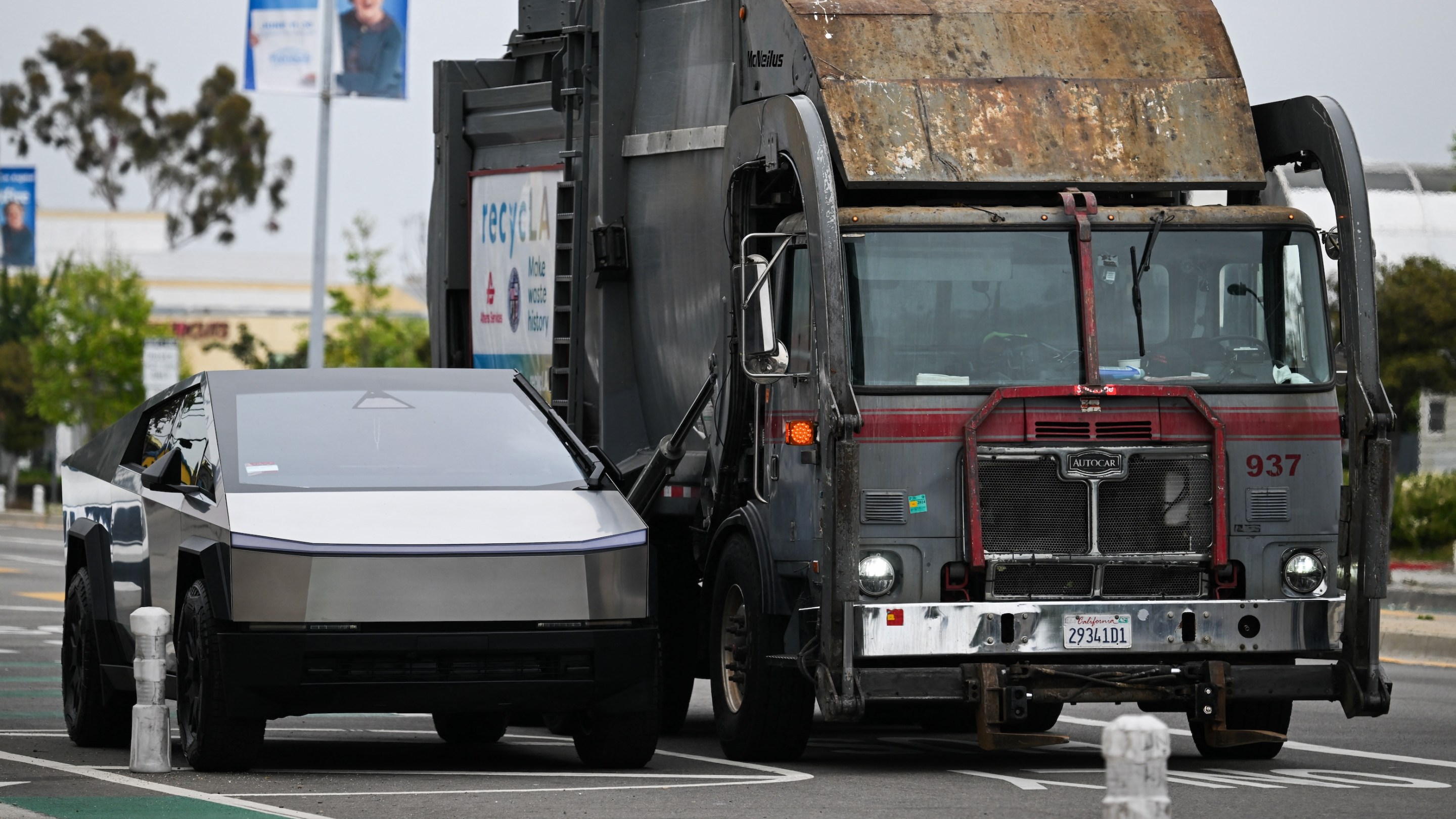 A Tesla Cybertruck electric vehicle sits parked next to a garbage truck in Los Angeles.