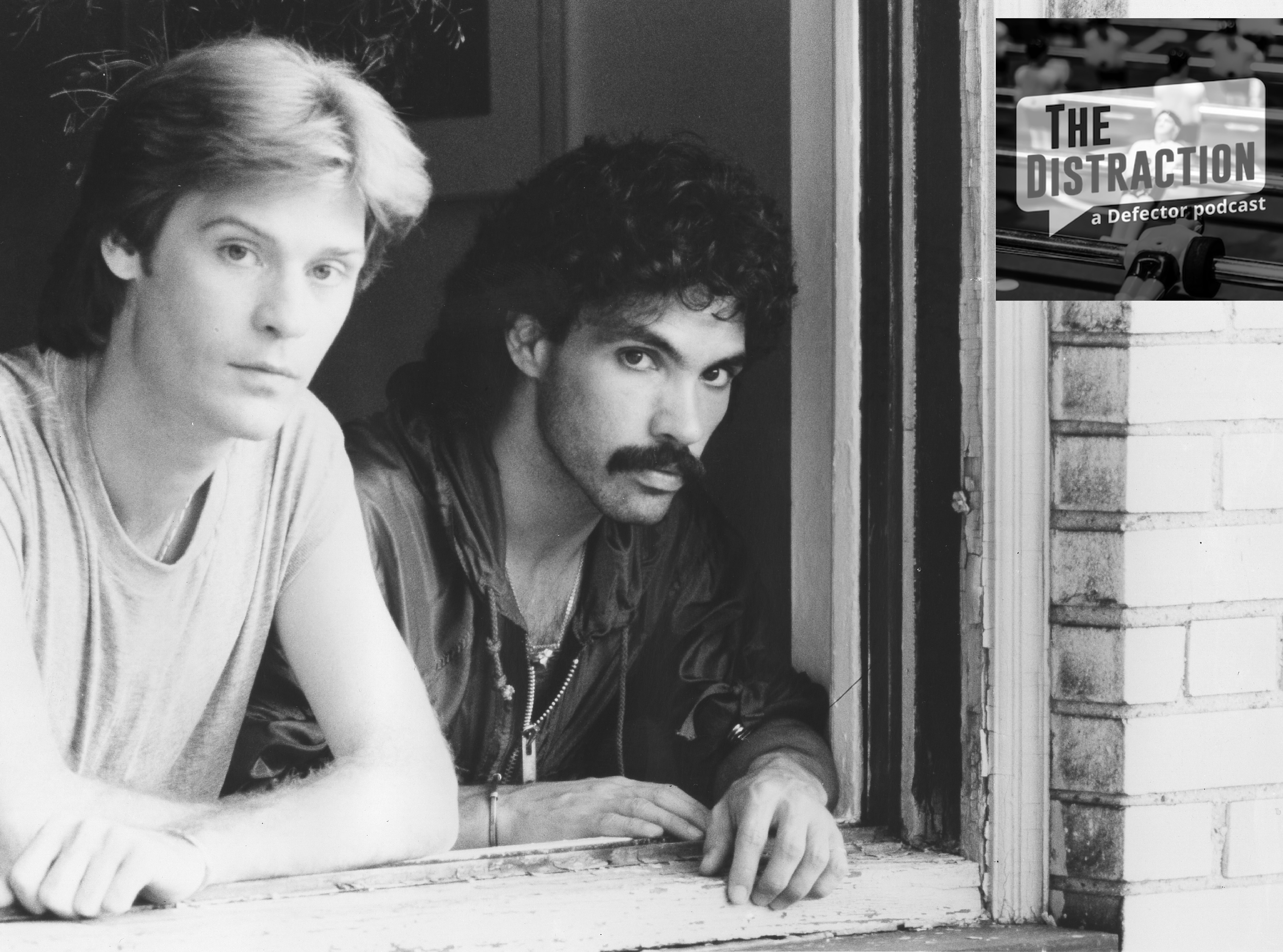 A black-and-white 1970 photograph of Hall & Oates looking out the window of an apartment building, taken by Michael Ochs. The Distraction logo is at upper right.