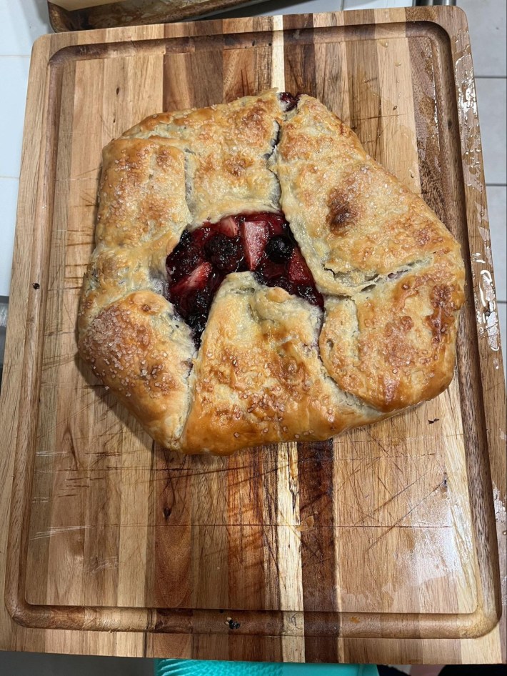 A gorgeous berry galette on a cutting board.