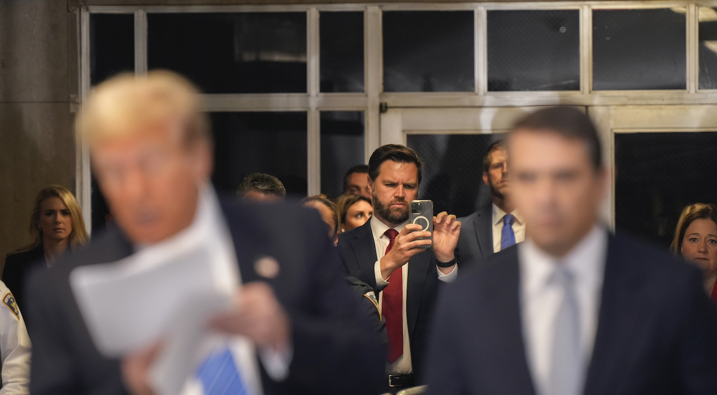U.S. Senator JD Vance takes pictures as Former President Donald Trump speaks to reporters at Manhattan criminal court, Monday, May 13, 2024, in New York.