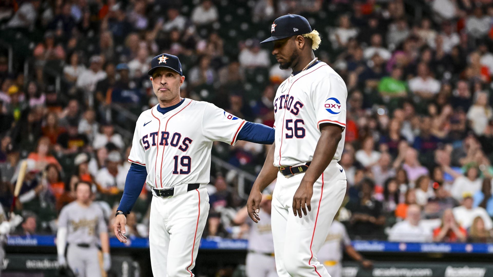 Ronel Blanco #56 is walked off the field by Joe Espada #19 of the Houston Astros after being ejected in the fourth inning against the Oakland Athletics.