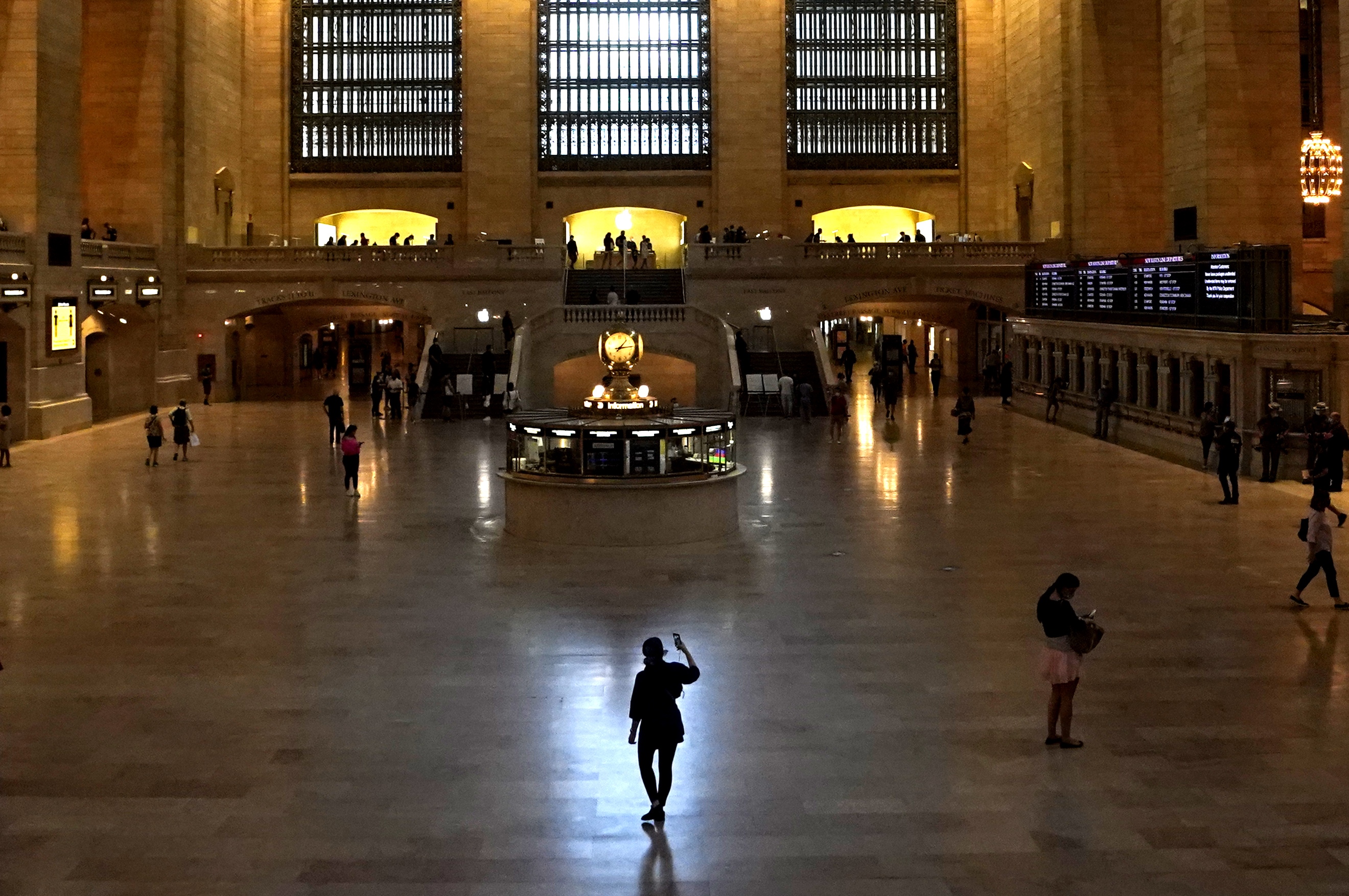 A woman stands with her cellphone in Grand Central Terminal, the historic world-famous landmark and transportation hub in Midtown Manhattan July 21, 2020 in New York. - The station is the southern terminus of the Metro-North Railroad's Harlem, Hudson and New Haven Lines and ridership has been down during the height of the coronavirus pandemic. (Photo by TIMOTHY A. CLARY / AFP) (Photo by TIMOTHY A. CLARY/AFP via Getty Images)