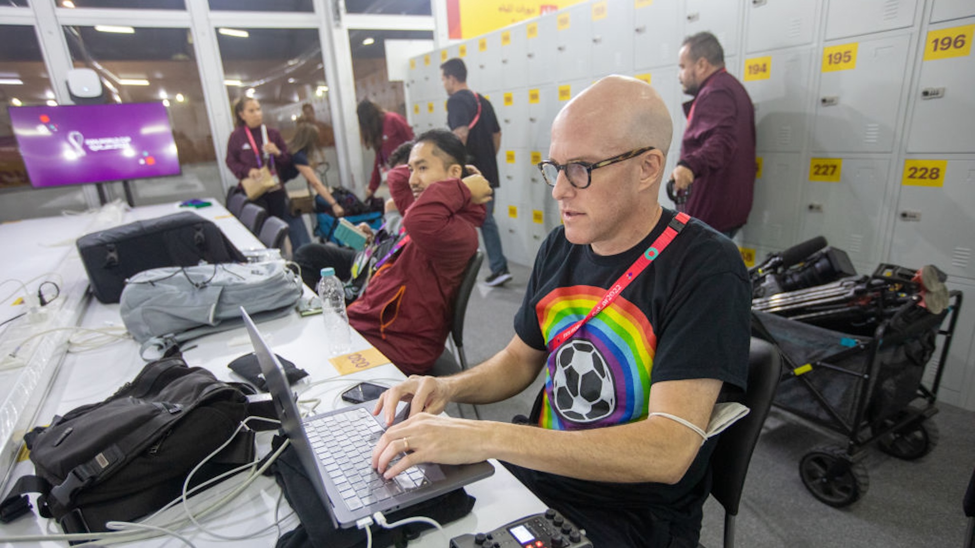 Journalist Grant Wahl (right) works in the FIFA Media Center before a FIFA World Cup Qatar 2022 Group B match between Wales and USMNT at Ahmad Bin Ali Stadium on November 21, 2022 in Al Rayyan, Qatar. He had been detained earlier by stadium security for wearing a rainbow-colored t-shirt before later being allowed to enter the stadium.