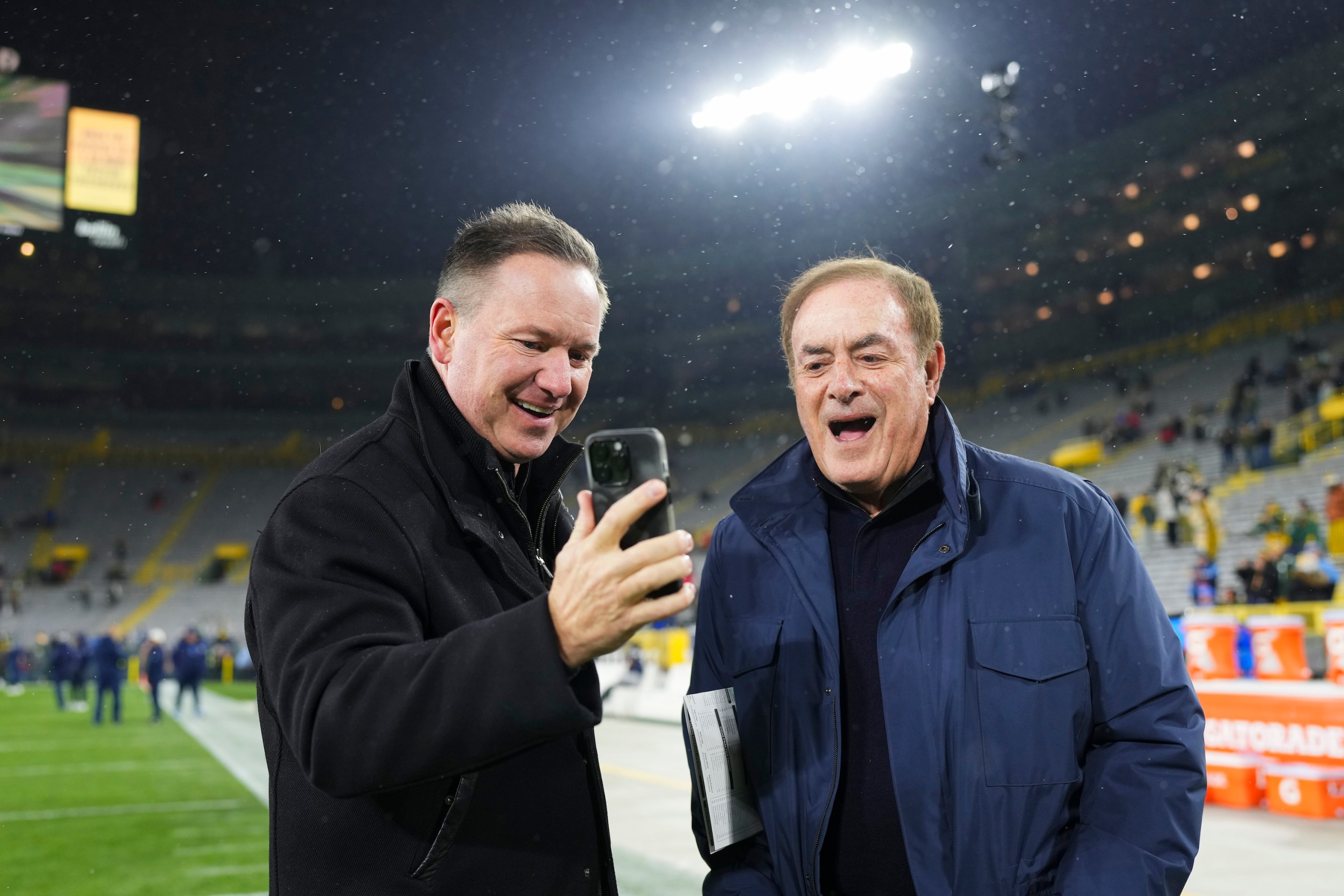 Al Michaels looks at an iPhone prior to the game between the Tennessee Titans and the Green Bay Packers at Lambeau on November 17, 2022.