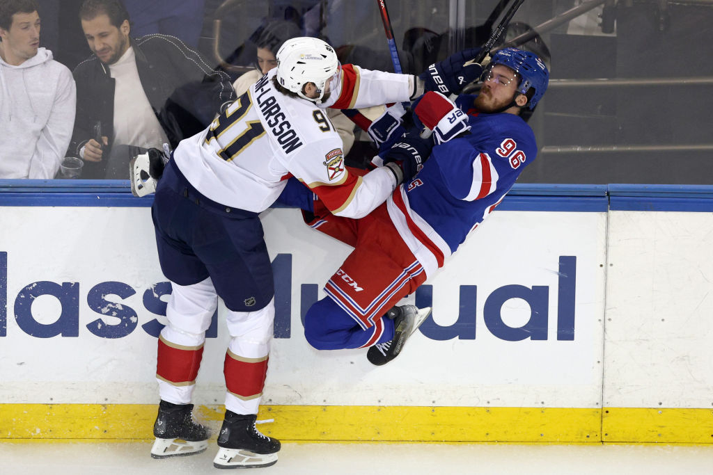 Oliver Ekman-Larsson #91 of the Florida Panthers checks Jack Roslovic #96 of the New York Rangers into the boards