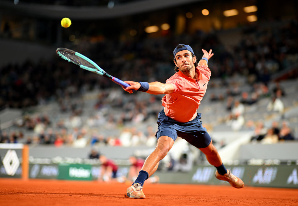 Lorenzo Musetti stretches to play a backhand
