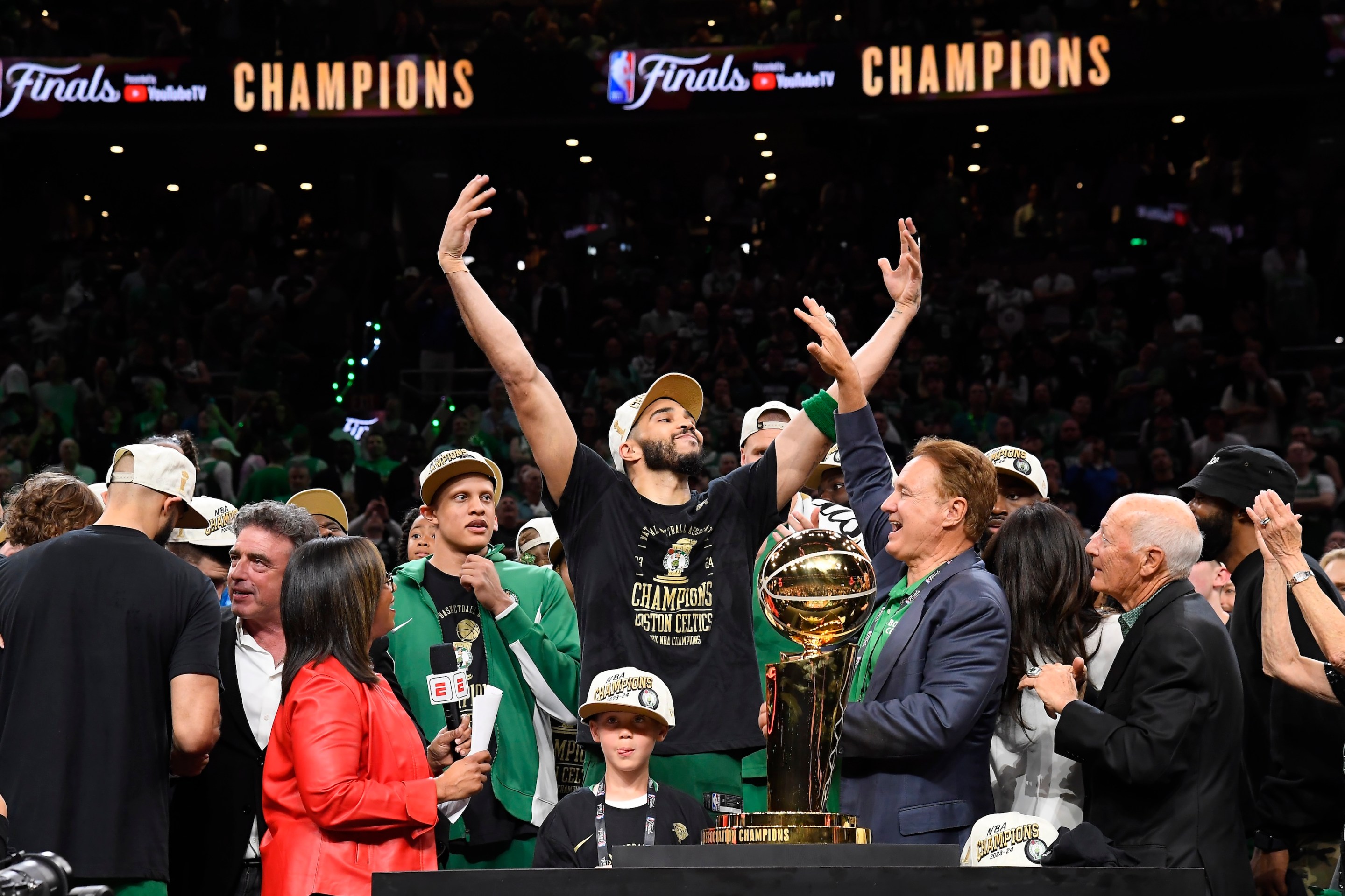 Jayson Tatum of the Boston Celtics exults near the Larry O'Brien Trophy after his team's win in the decisive Game 5 of the 2024 NBA Finals.