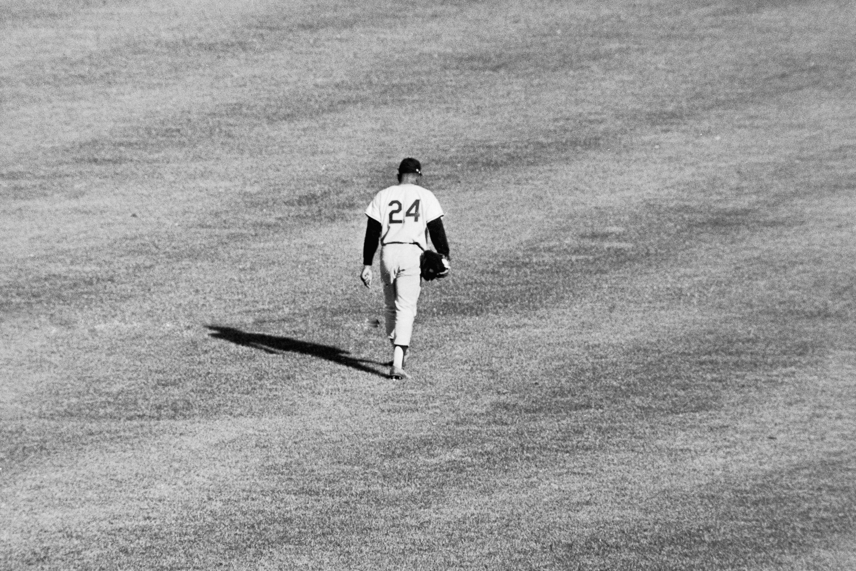 Willie Mays walking across the outfield at the Polo Grounds as a member of the San Francisco Giants during a 1962 game against the New York Mets.