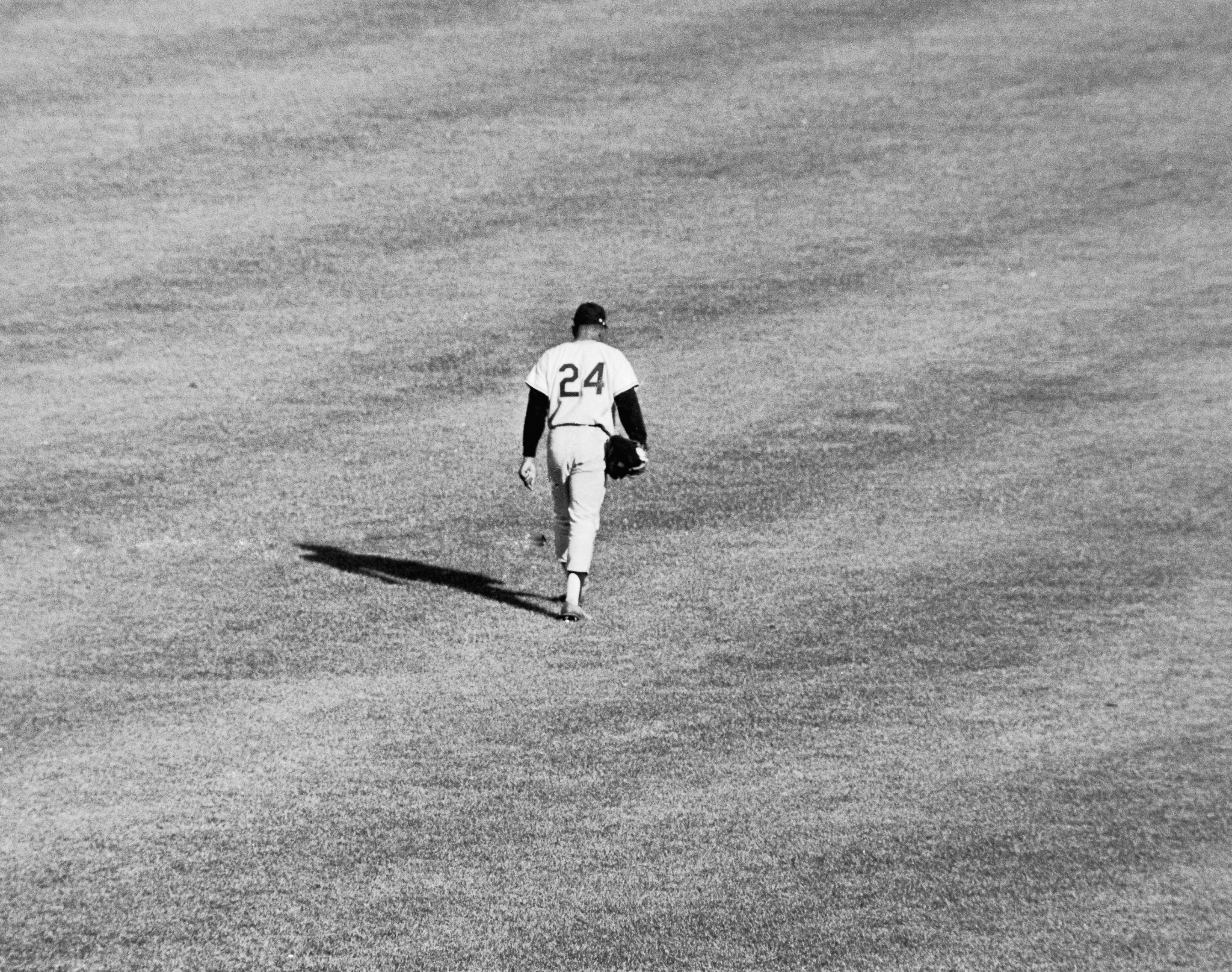 Willie Mays walking across the outfield at the Polo Grounds as a member of the San Francisco Giants during a 1962 game against the New York Mets.