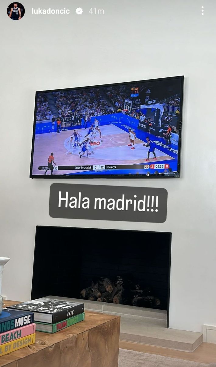 Luka Doncic's living room sports-watching setup, a TV hung directly over a little gas fireplace with a big wood coffee table in the shot.