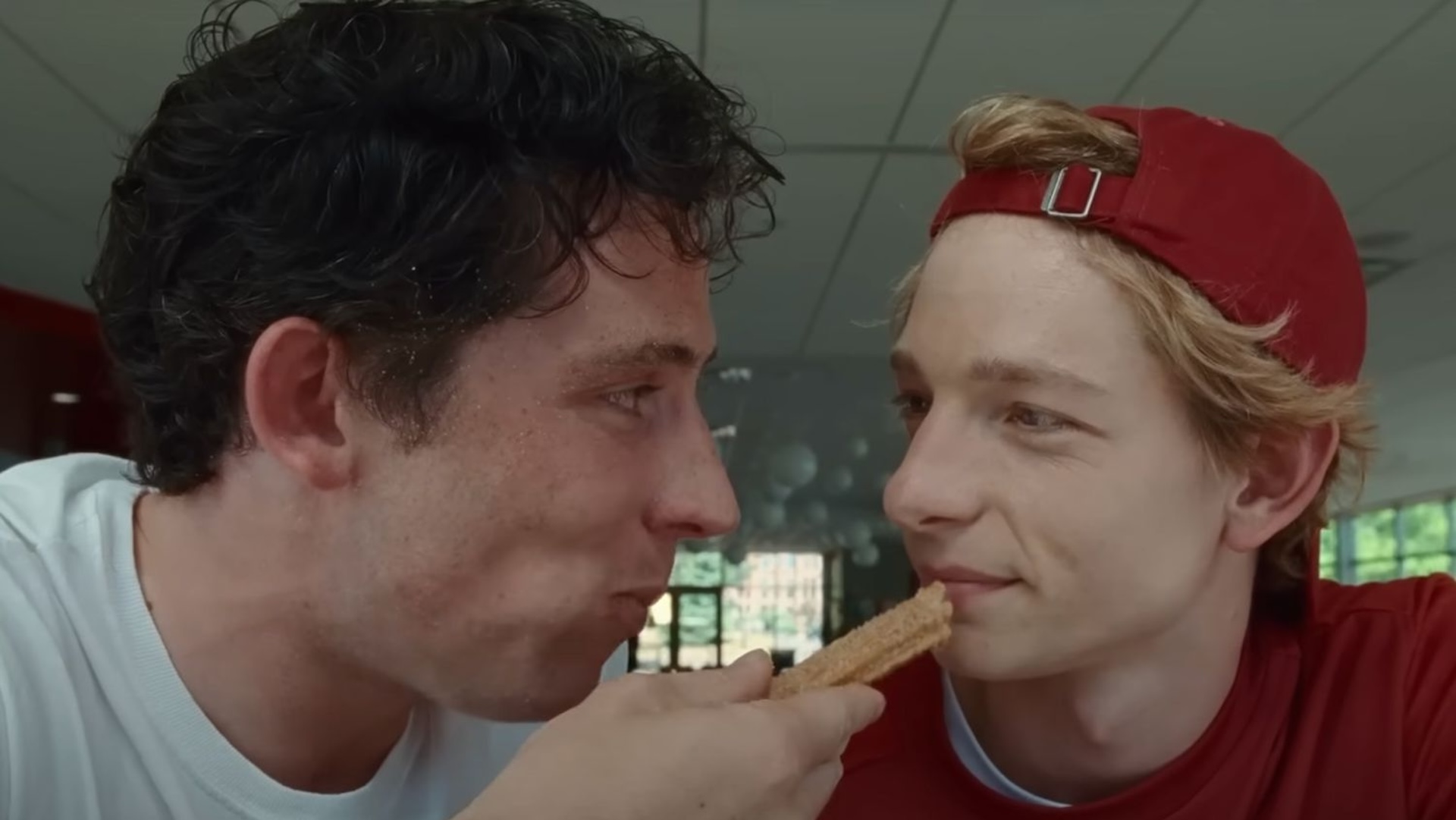 Josh O'Connor feeds a churro to Mike Faist in a scene from Challengers