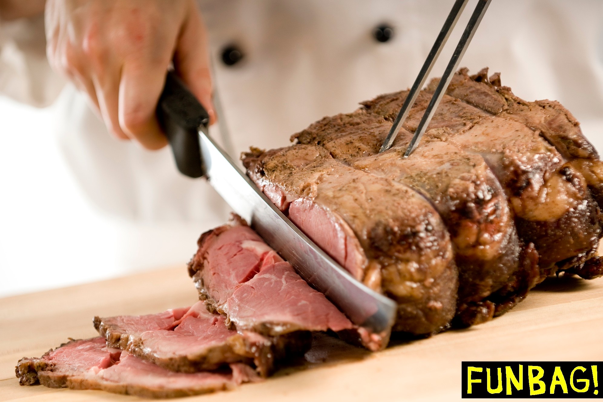 Chef carving perfectly cooked prime rib roast beef
