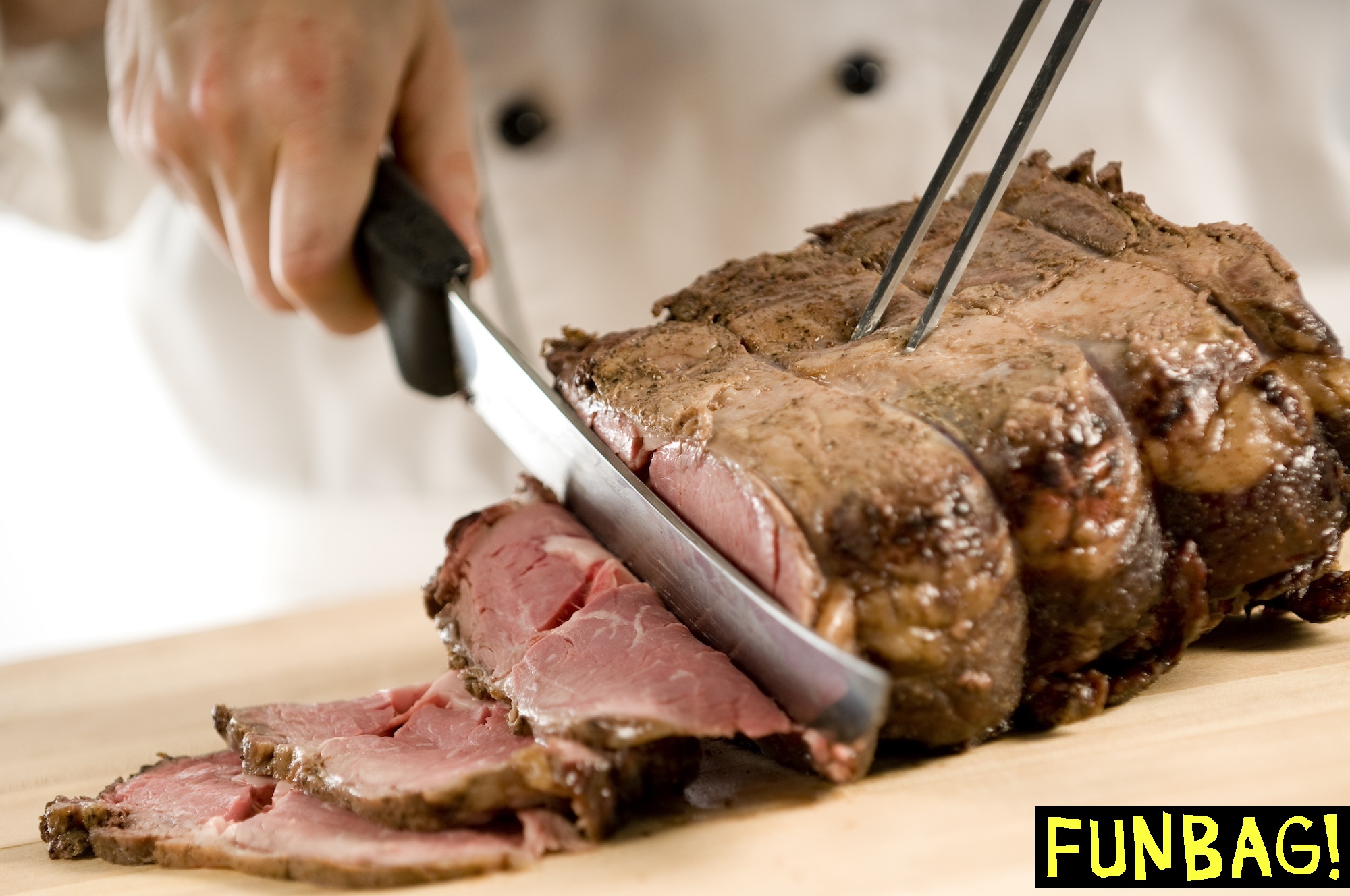 Chef carving perfectly cooked prime rib roast beef