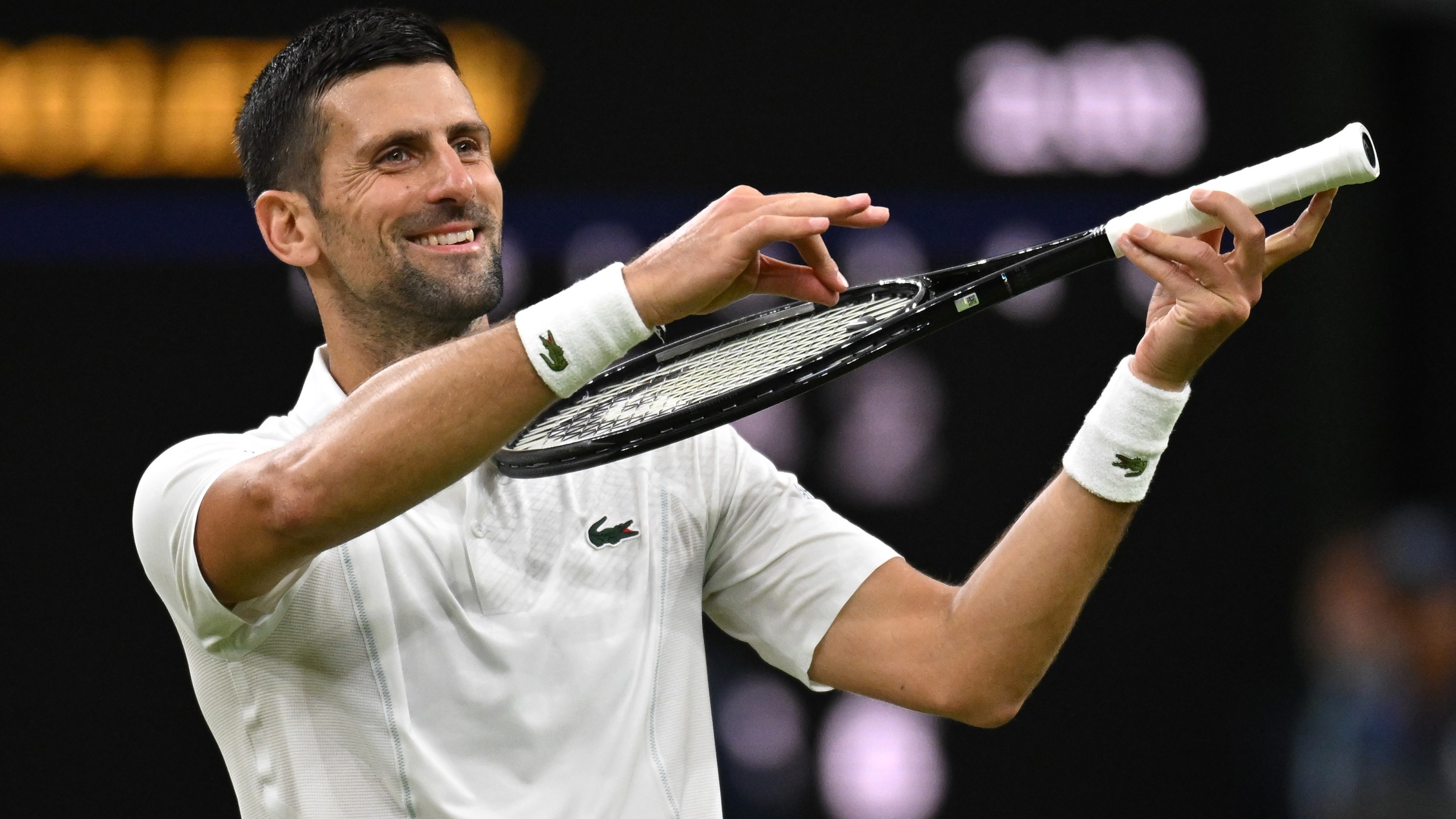 Novak Djokovic of Serbia celebrates winning match point with a violin gesture against Holger Rune of Denmark in his Gentlemen's Singles fourth round match during day eight of The Championships Wimbledon 2024 at All England Lawn Tennis and Croquet Club on July 08, 2024 in London, England.