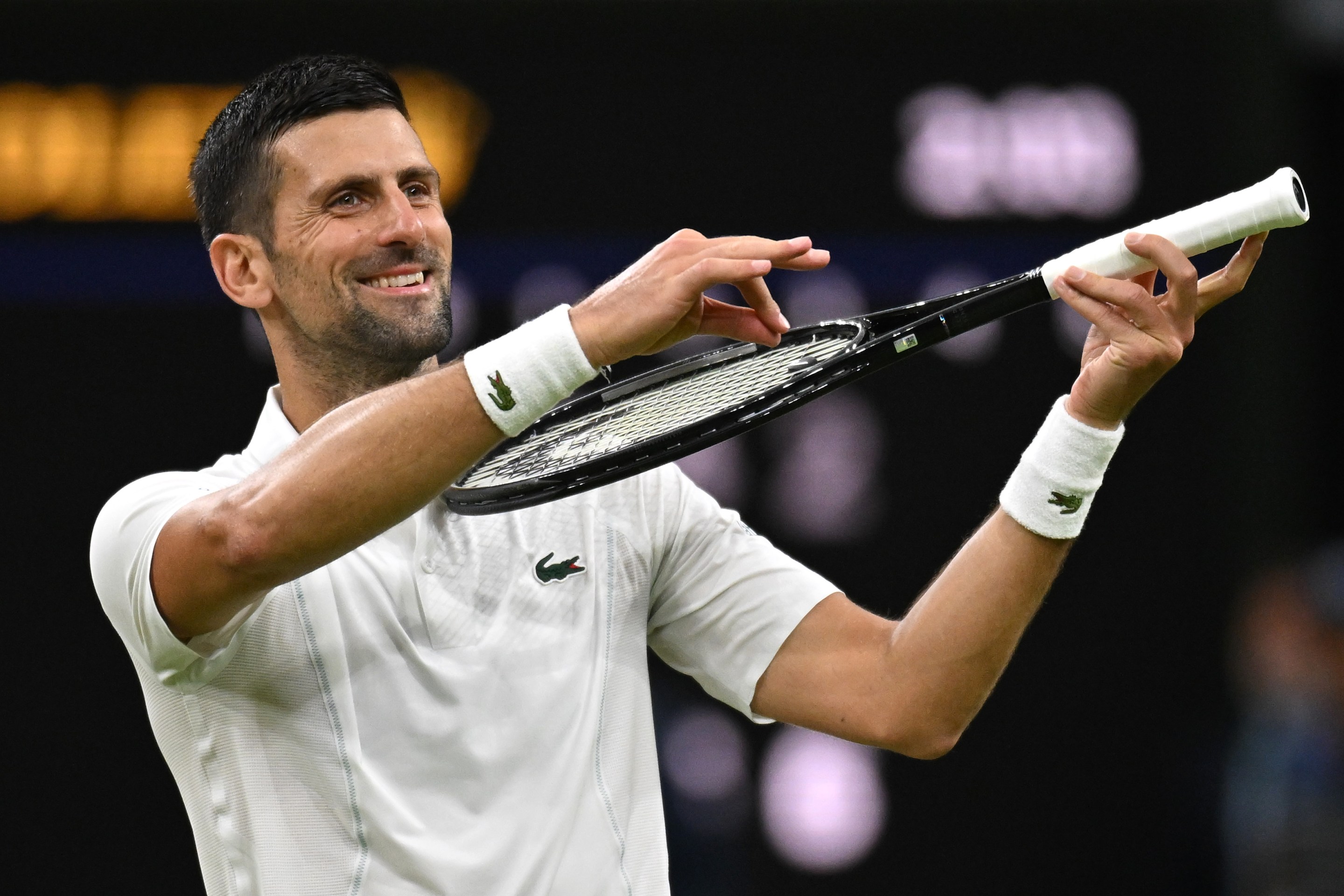 Novak Djokovic of Serbia celebrates winning match point with a violin gesture against Holger Rune of Denmark in his Gentlemen's Singles fourth round match during day eight of The Championships Wimbledon 2024 at All England Lawn Tennis and Croquet Club on July 08, 2024 in London, England.
