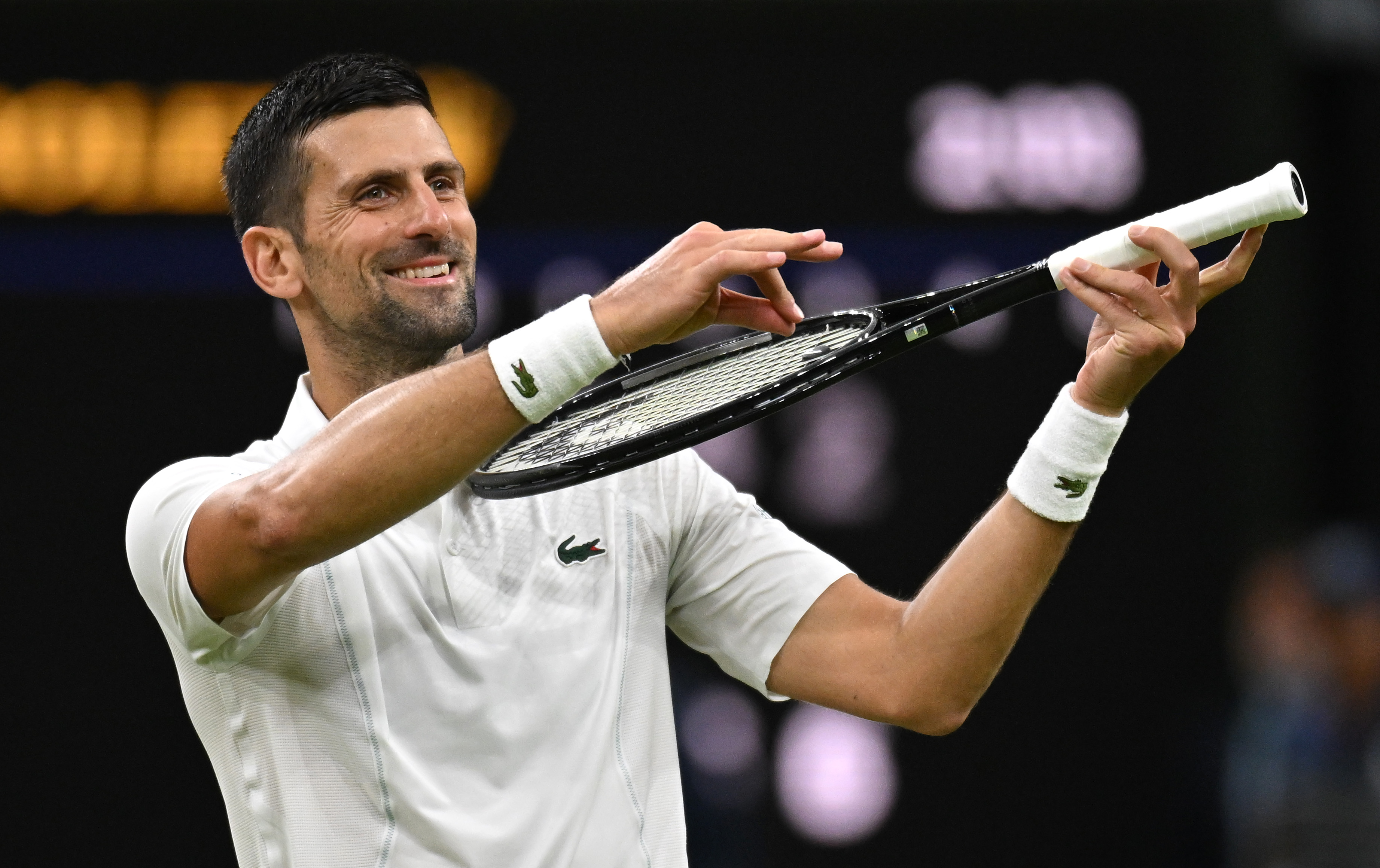 Novak Djokovic of Serbia celebrates winning match point with a violin gesture against Holger Rune of Denmark in his Gentlemen's Singles fourth round match during day eight of The Championships Wimbledon 2024 at All England Lawn Tennis and Croquet Club on July 08, 2024 in London, England.