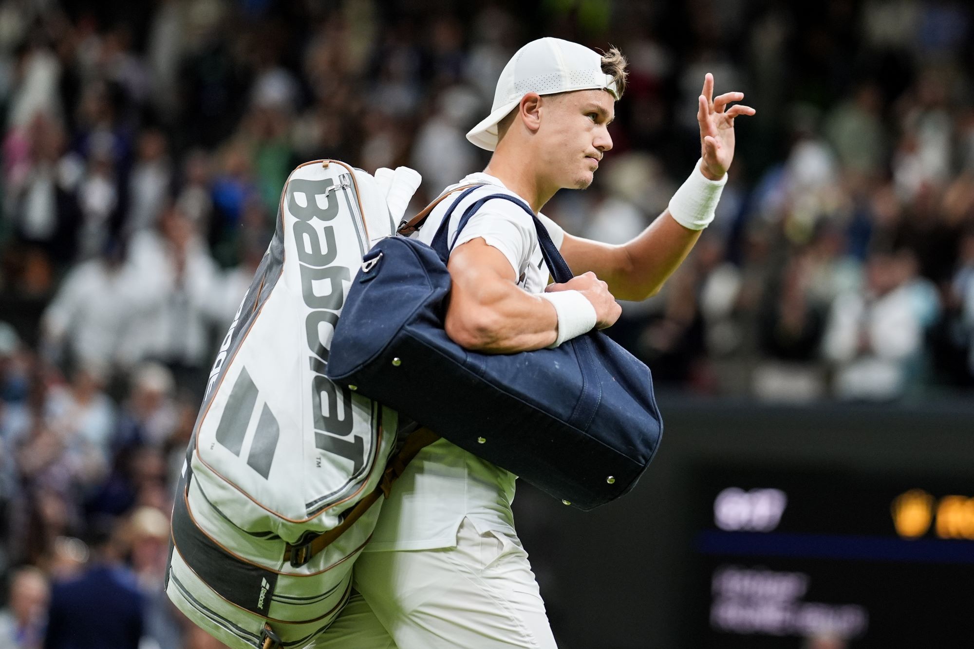 Holger Rune carrying his bags on the court