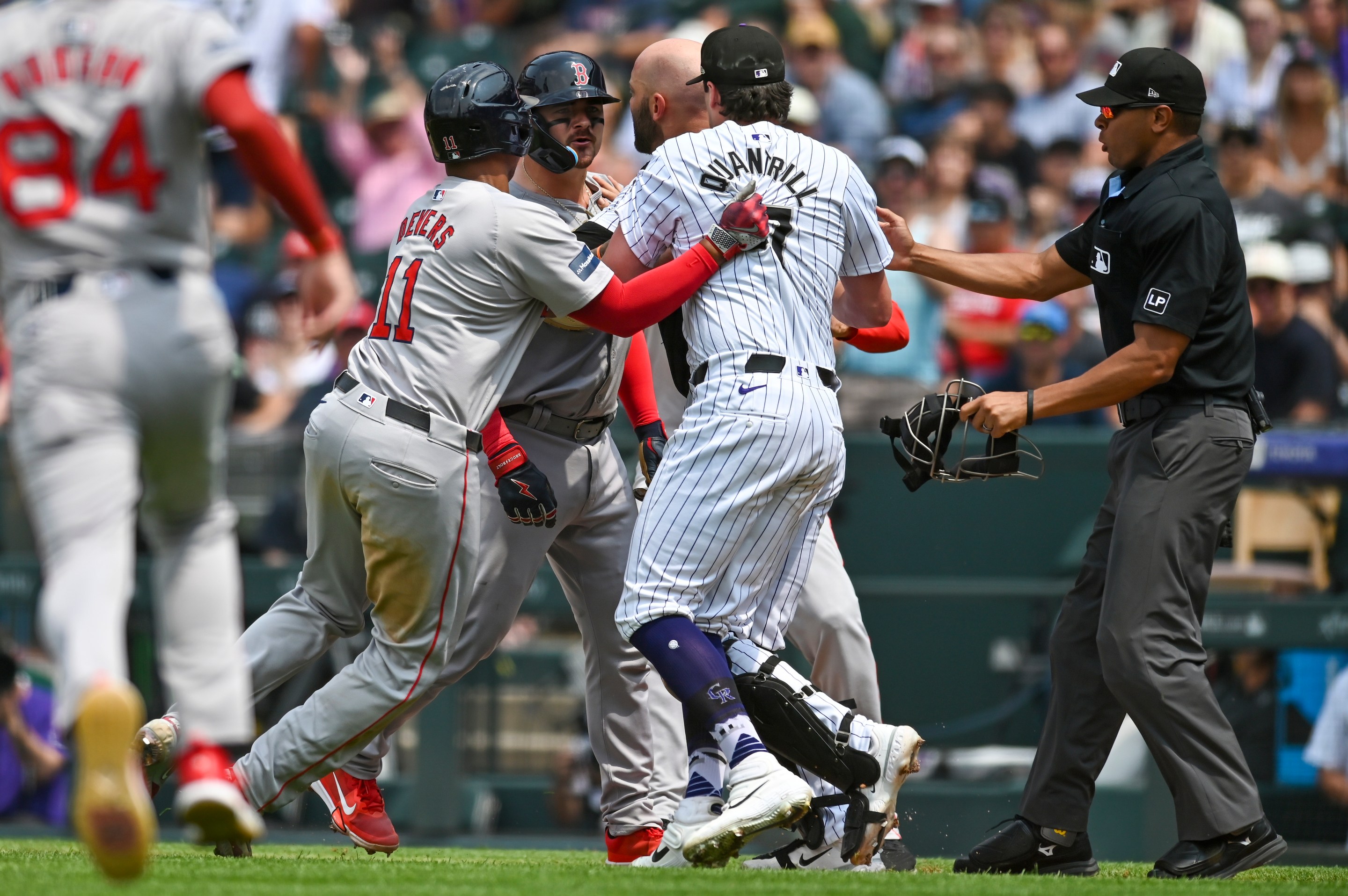 Colorado Rockies pitcher Cal Quantrill (47) and Boston Red Sox catcher Reese McGuire (3) exchange words as Boston Red Sox third baseman Rafael Devers (11) and Colorado Rockies catcher Jacob Stallings (25) try to separate them, during a game between the Boston Red Sox and the Colorado Rockies at Coors Field in Denver, CO on July 24, 2024.