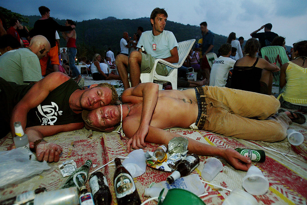 two men sleep on the beach