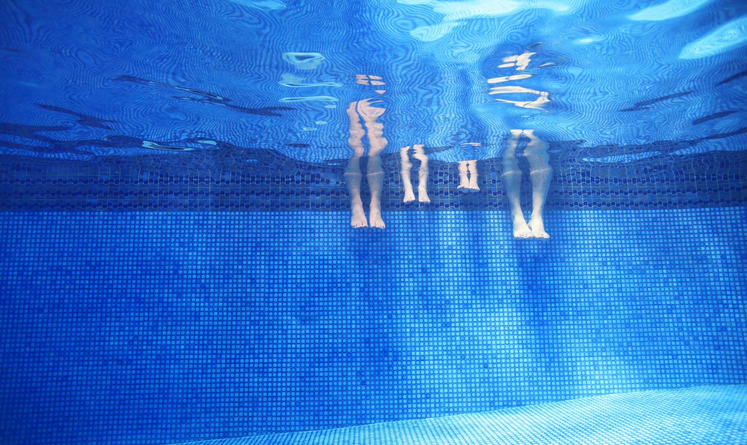Swimming pool , family , legs - stock photo