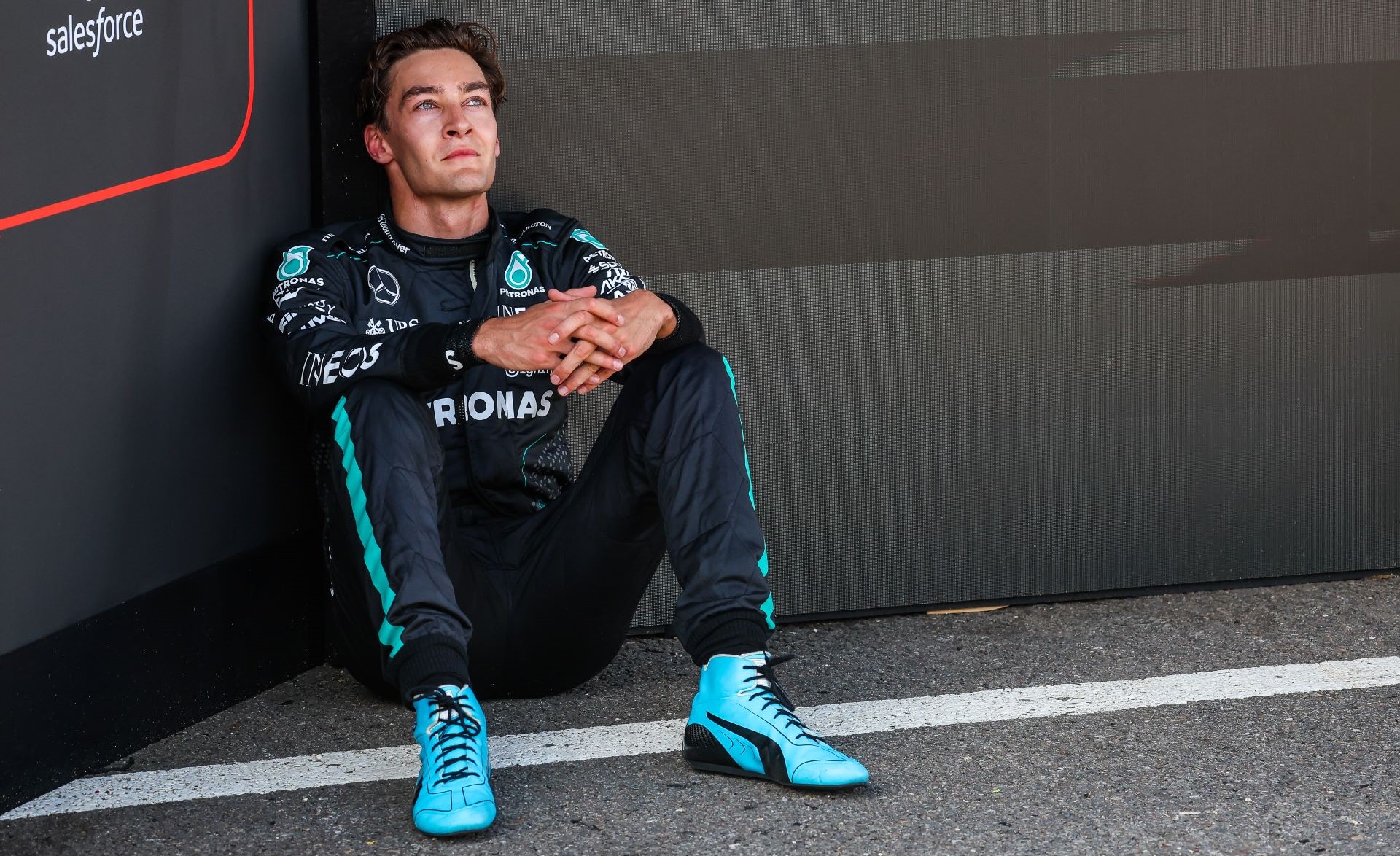 Race winner George Russell of Great Britain and Mercedes sits on the ground in parc ferme after winning the F1 Grand Prix of Belgium.