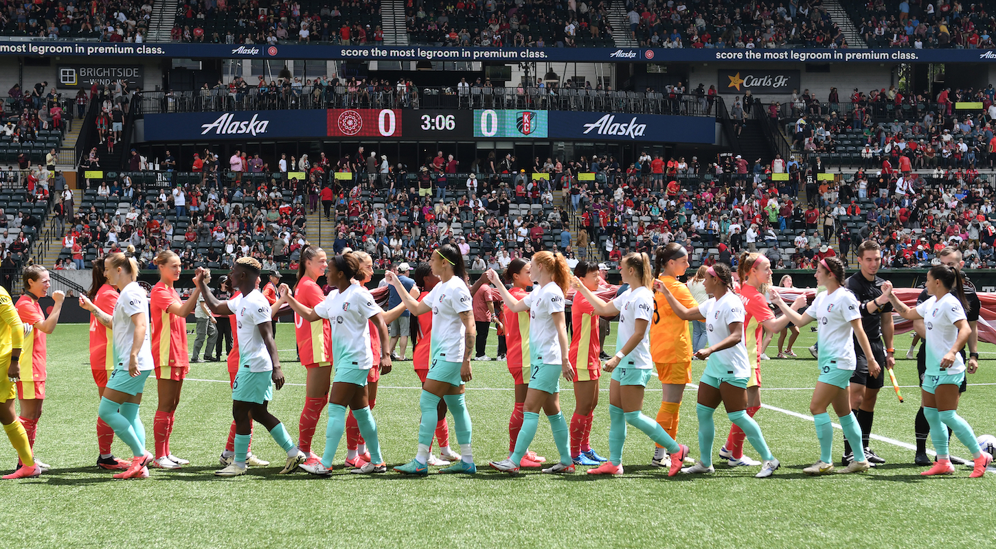 Players give high-fives after the National Anthem before an NWSL match between the Portland Thorns and Kansas City Current on June 23, 2024 in Portland, Oregon.