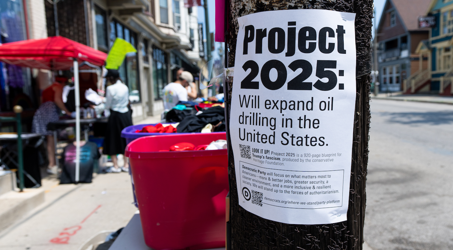A flyer with information about Project 2025's plan to expand oil drilling inside the United States, stapled to a pole on a city street in Milwaukee, Wisconsin.
