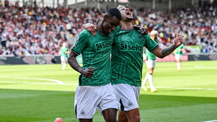 Alexander Isak of Newcastle United (14) celebrates with teammate Bruno Guimaraes after scoring the third goal during the Premier League match between Brentford FC and Newcastle United at Brentford Community Stadium on May 19, 2024 in Brentford, England.