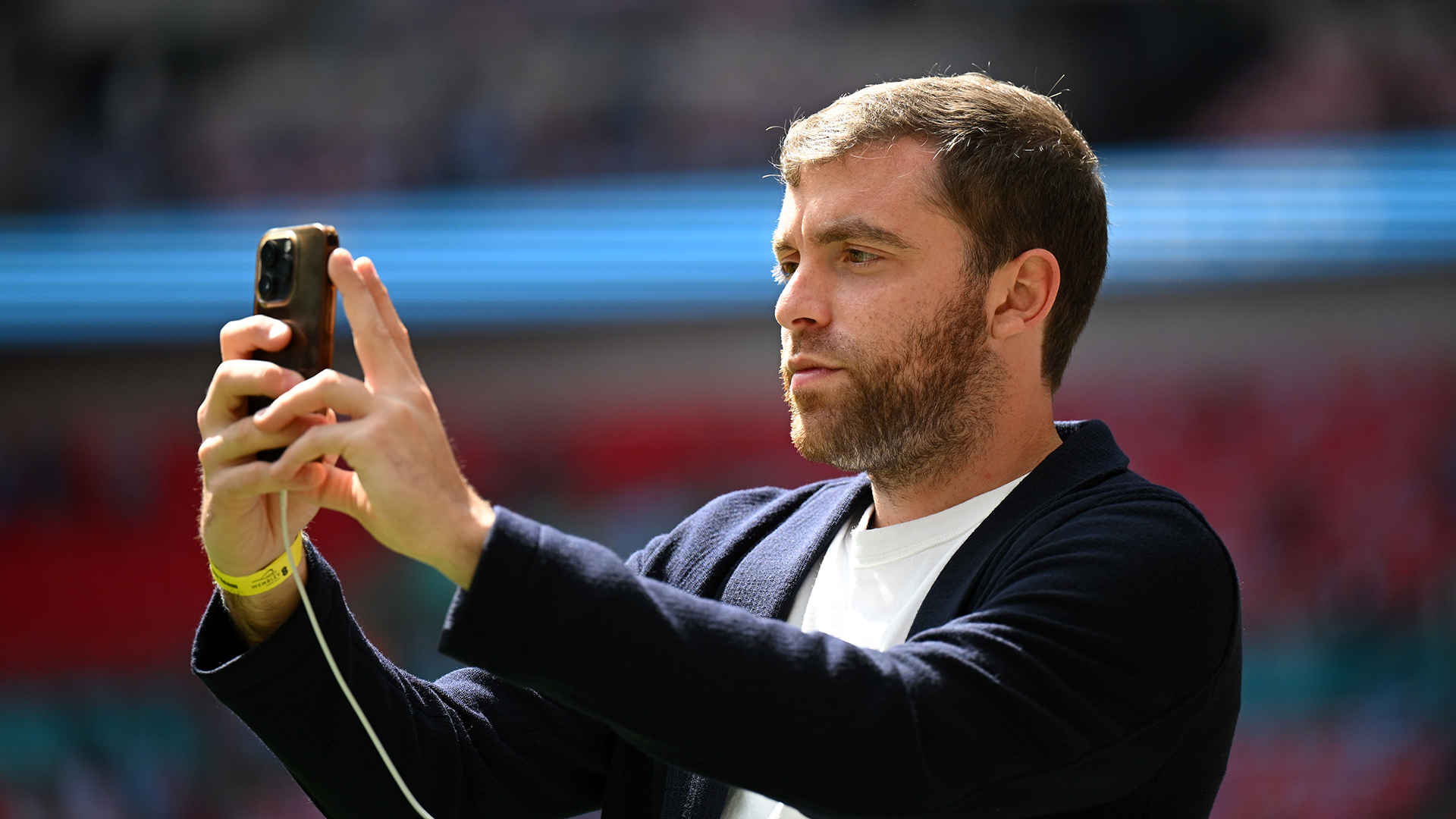 Italian Sports Journalist, Fabrizio Romano, looks on with his phone prior to the Emirates FA Cup Final match between Manchester City and Manchester United at Wembley Stadium on May 25, 2024 in London, England.