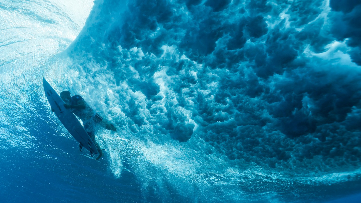 TOPSHOT - France's Kauli Vaast duckdives a wave in the 7th heat of the men's surfing round 1, during the Paris 2024 Olympic Games, in Teahupo'o, on the French Polynesian Island of Tahiti, on July 27, 2024. (Photo by Ben Thouard / POOL / AFP) (