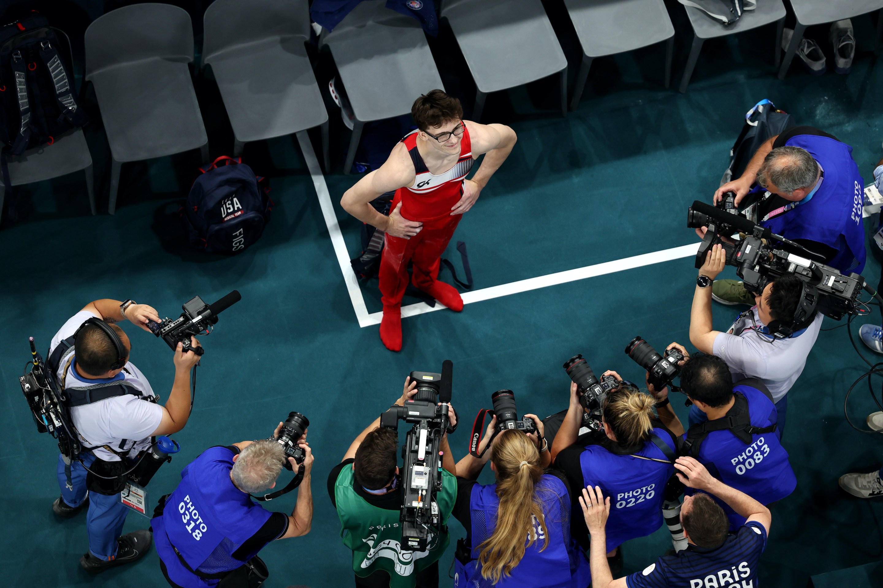 American gymnast Stephen Nedoroscik surrounded by press with cameras at the Olympics in Paris.