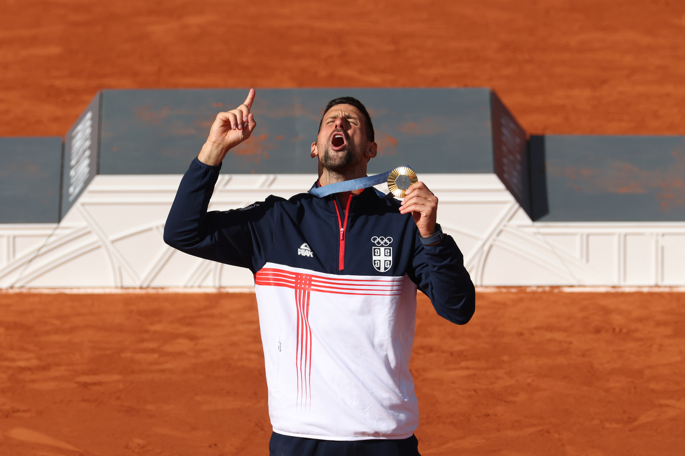 PARIS, FRANCE - AUGUST 04: Gold medallist Novak Djokovic of Team Serbia celebrates during the Tennis Men's Singles medal ceremony after the Tennis Men's Singles Gold medal match on day nine of the Olympic Games Paris 2024 at Roland Garros on August 04, 2024 in Paris, France. (Photo by Matthew Stockman/Getty Images)