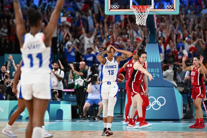 France's #15 Gabby Williams (C) after scoring a last second two-point goal in the women's Gold Medal basketball match between France and the USA during the Paris 2024 Olympic Games at the Bercy Arena in Paris on August 11, 2024.