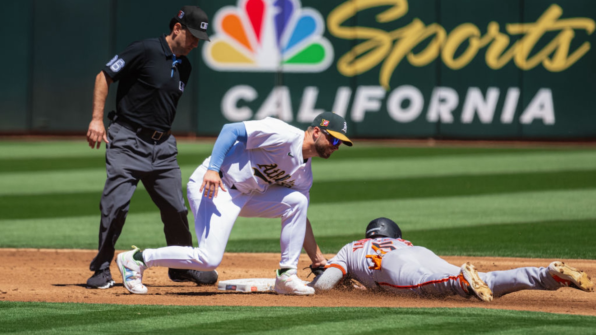 Oakland Athletics shortstop Max Schuemann (12) tags out San Francisco Giants outfielder Mike Yastrzemski (5) during an MLB game between the San Francisco Giants and Oakland Athletics on August 18, 2024, at the Oakland-Alameda County Coliseum in Oakland, CA.