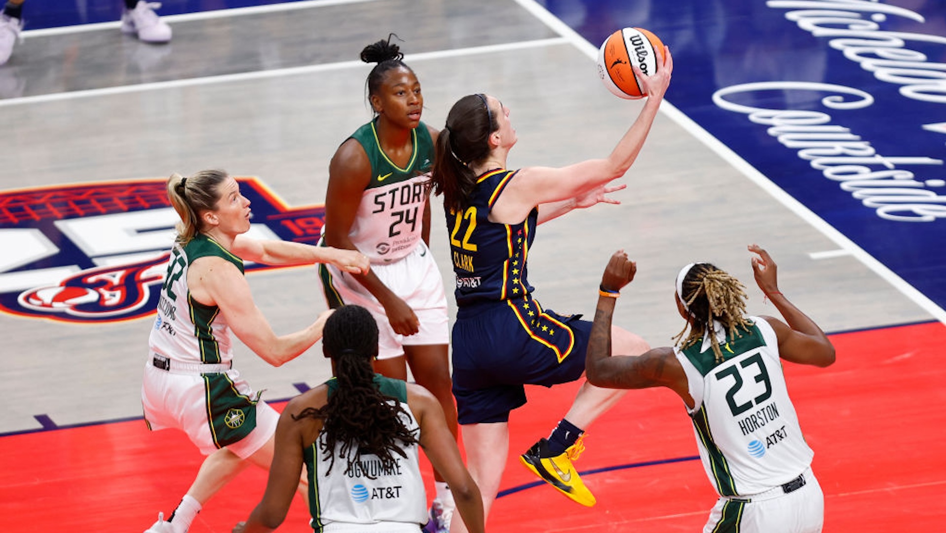 Indiana Fever guard Caitlin Clark (22) drives past the Seattle Storm defenders and goes up with her layup for two in the second quarter of play during a WNBA game between the Seattle Storm and the Indiana Fever on August 18, 2024 at Gainbridge Fieldhouse in Indianapolis, IN.