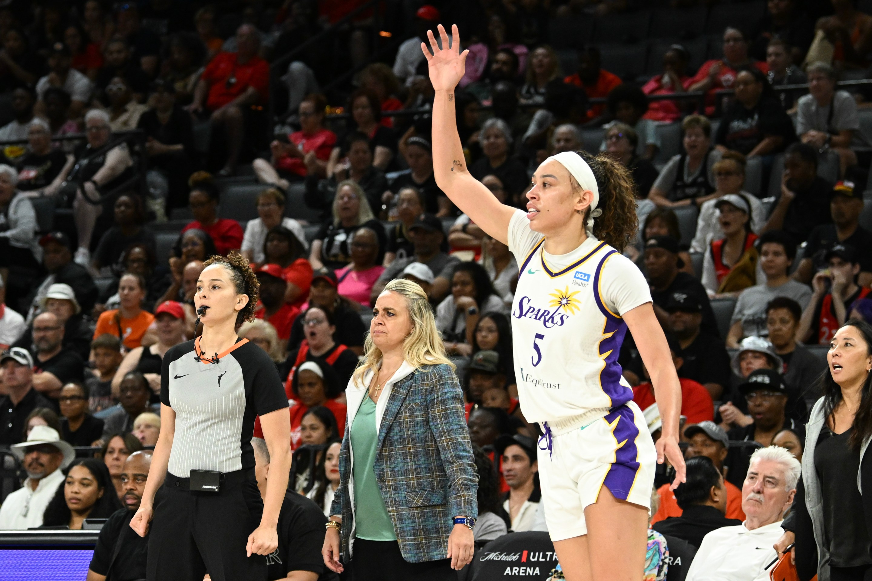 Head coach Becky Hammon of the Las Vegas Aces and Dearica Hamby #5 of the Los Angeles Sparks look on during the first half at Michelob ULTRA Arena on August 18, 2024 in Las Vegas, Nevada.