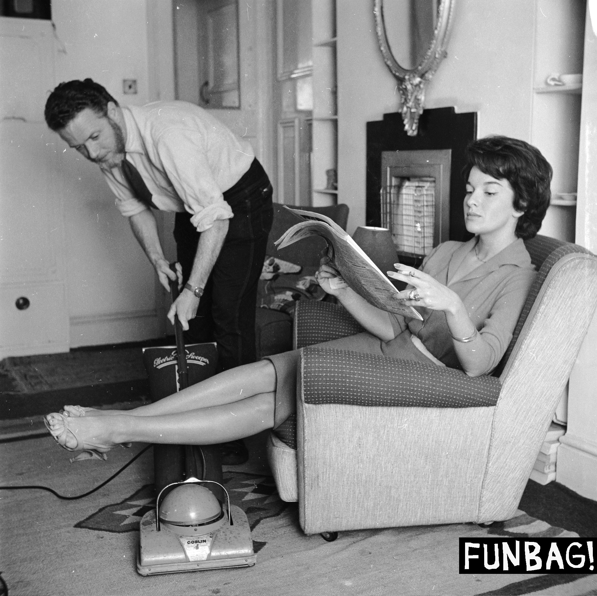 September 1958: An employee of the 'Housewives Help Service' hoovering the living room of a businesswoman while she relaxes. (Photo by Frank Martin/BIPs/Getty Images)